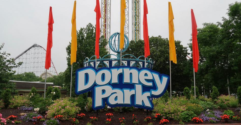 Sign with the park logo on a background of carousels