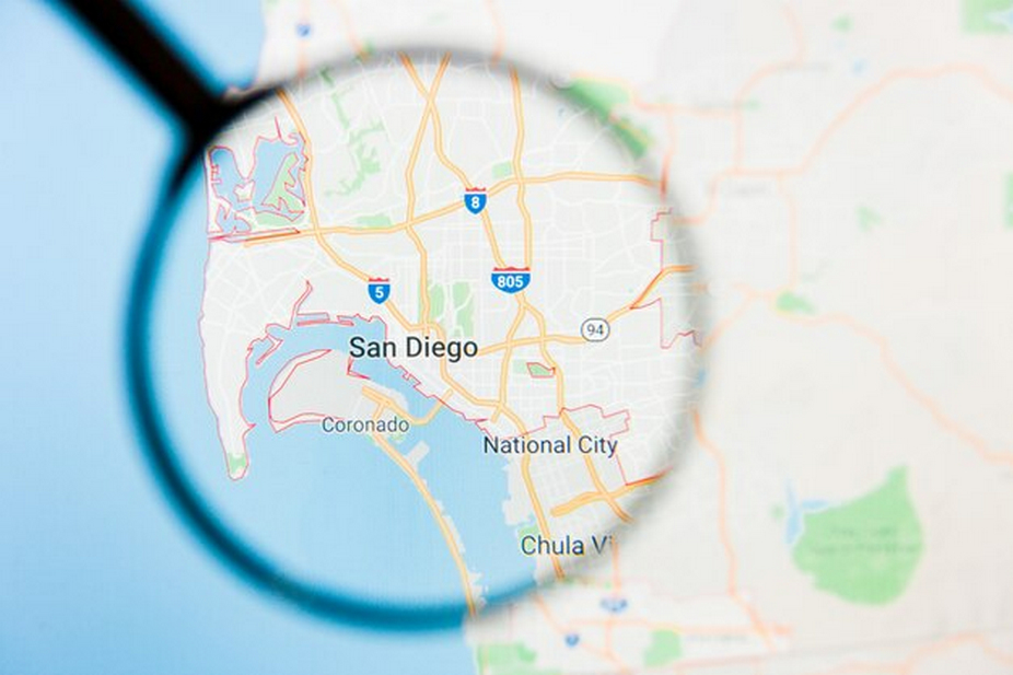 Magnifying glass on a map of the United States focused on San Diego.